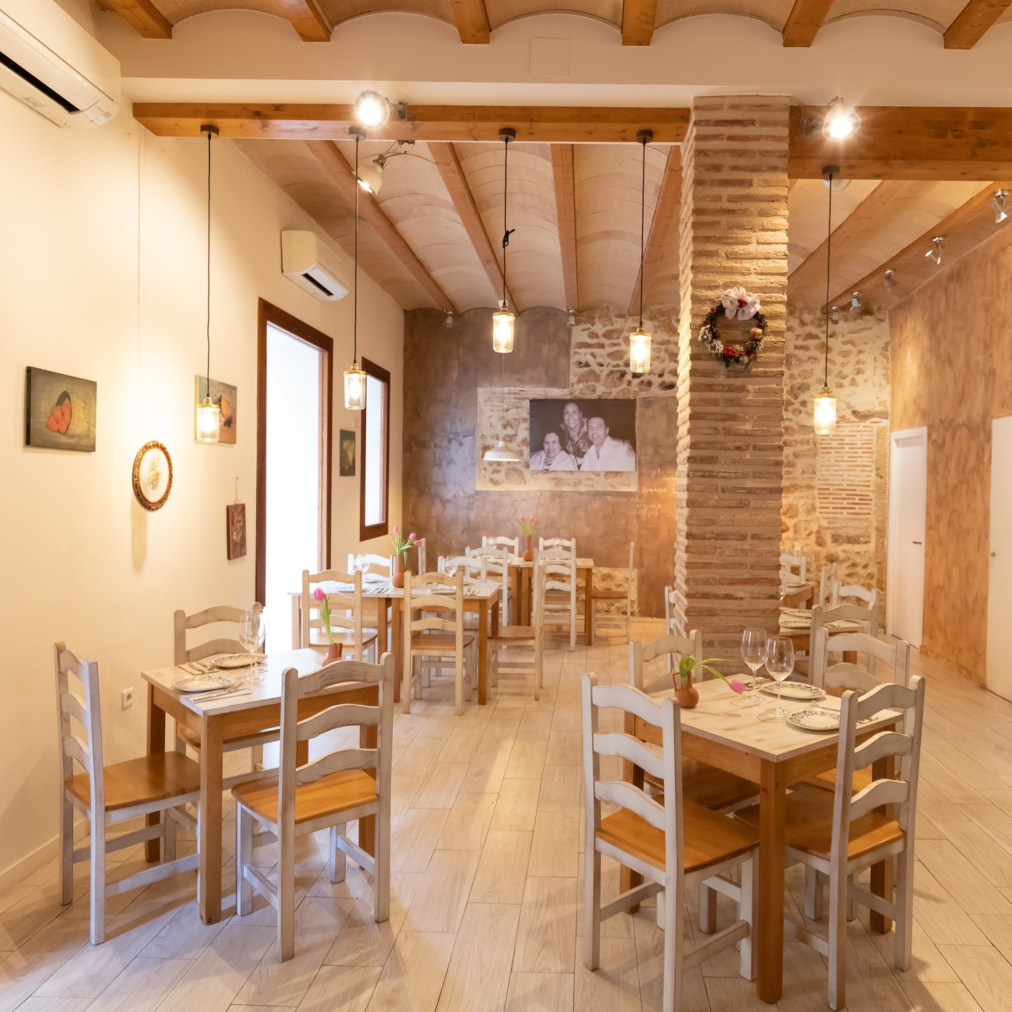 Sala del restaurante con paredes de piedra y mesas de pino
