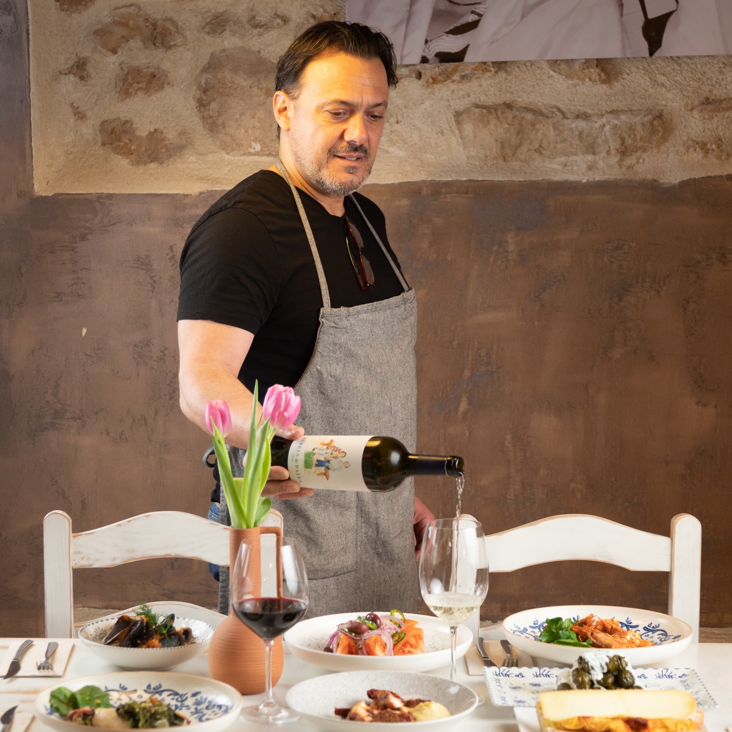 Constantinos sirviendo vino blanco